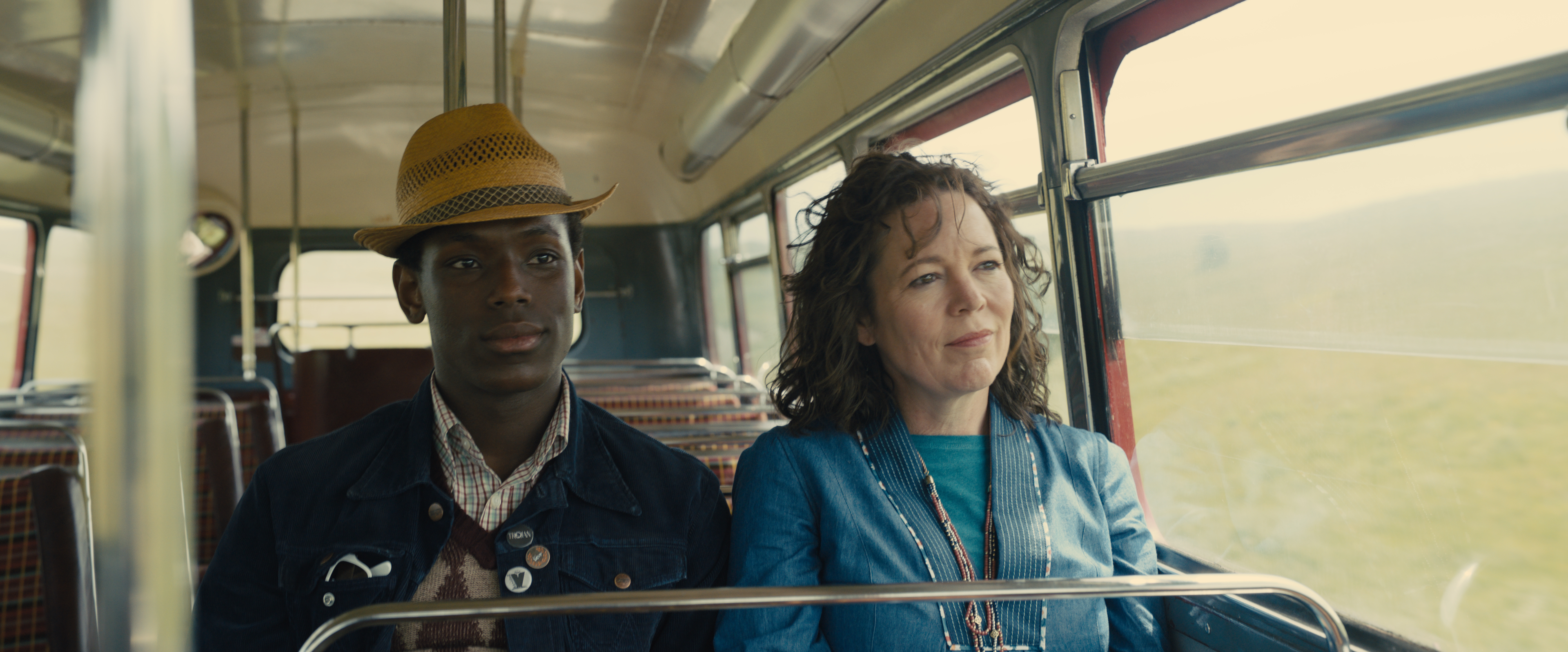 Image of Micheal Ward and Olivia Colman in the film EMPIRE OF LIGHT sitting side-by-side on a bus. Courtesy of Searchlight Pictures. © 2022 20th Century Studios All Rights Reserved.