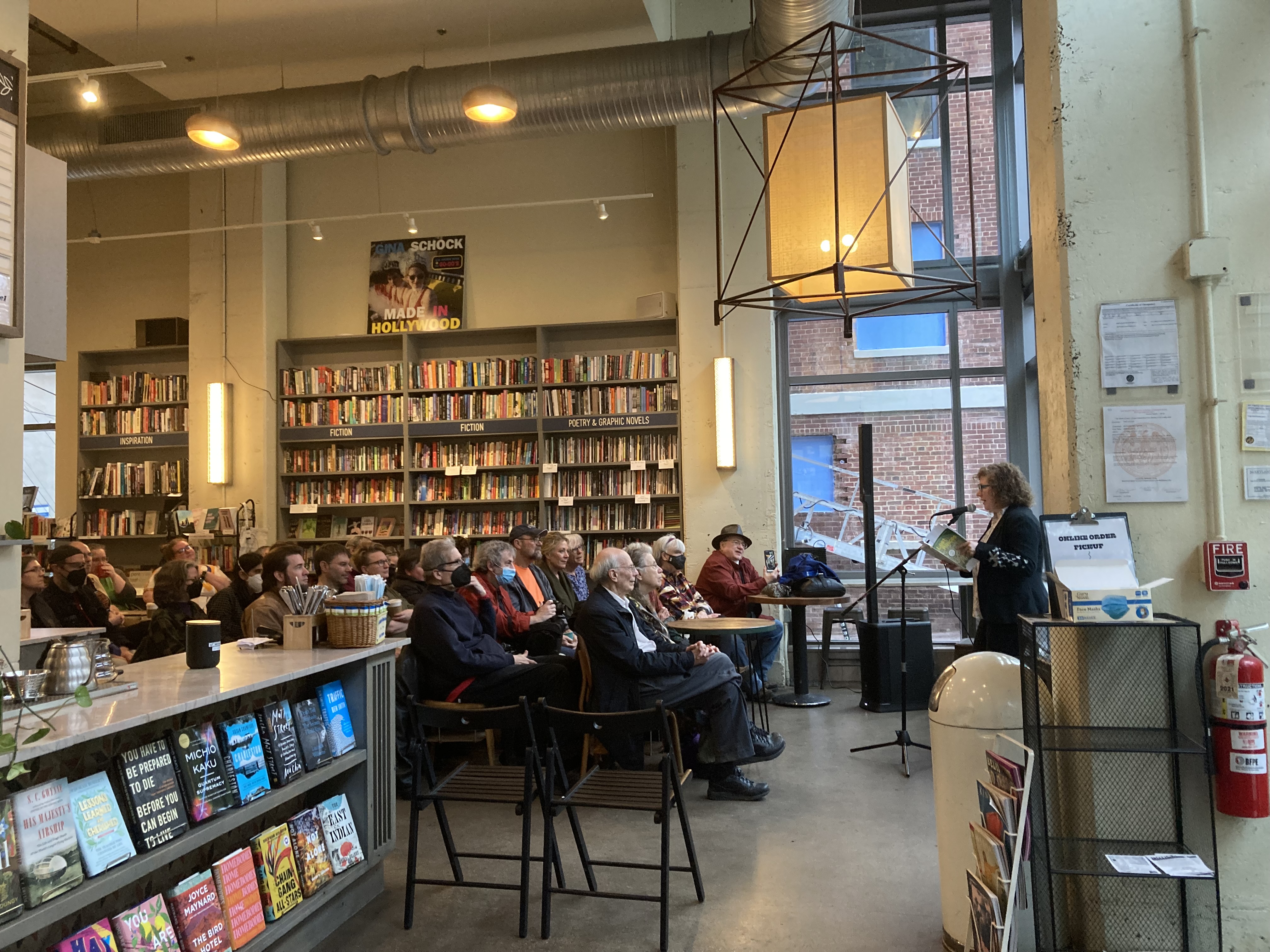 An author reading from their book in front of an audience inside Bird in Hand bookstore