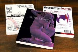 Image of three journal covers on a desk.