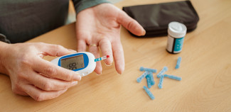 Person taking their blood sugar with a diabetes checker