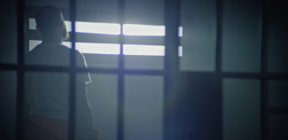 Image of man behind prison bars