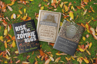 Books from Hopkins Press on a leafy background